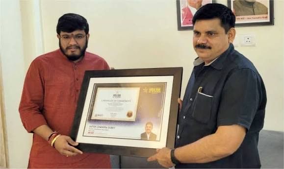 Satish Chandra Dubey and another man holding a framed certificate bearing his name and photograph