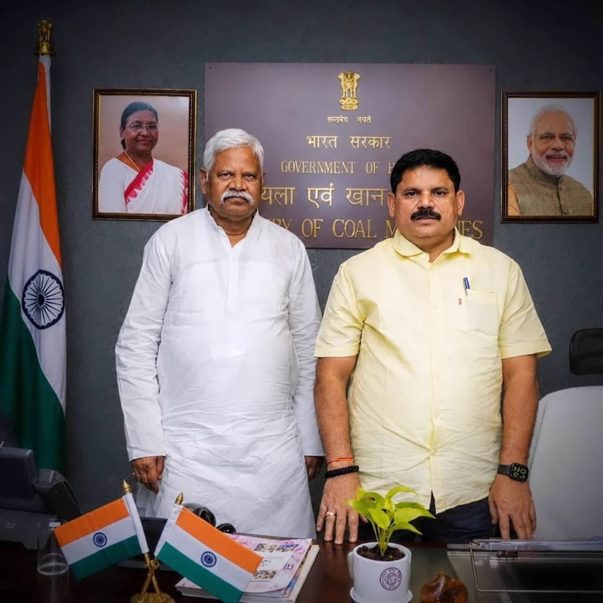 Satish Chandra Dubey standing beside a visitor in white in his ministry office, with the Government of India nameplate of the Ministry of Coal and Mines on the wall behind